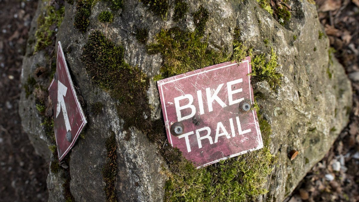 Ein Schild mit der Aufschrift «Bike Trail» (Fahrradweg) liegt auf einer Trail-Strecke in Zürich.