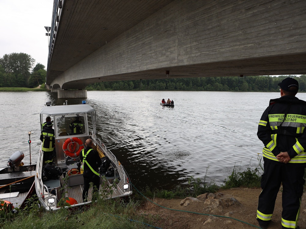 Rettungskräfte stehen am 23. Mai 2022 am Ufer der Donau in Oberbayern. Einige Kilometer flussabwärts wurde vor wenigen Tagen eine Kinderleiche aus dem Fluss geborgen.