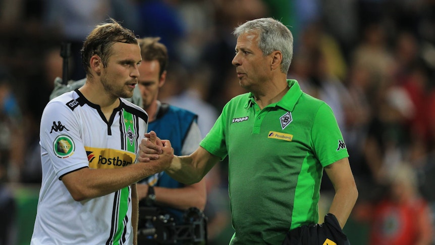 Der künftige Gladbach-Trainer Lucien Favre (r.) klatscht mit Borussia-Verteidiger Tony Jantschke (l.) ab. Dieses Foto stammt vom DFB-Pokalspiel der Fohlen-Elf beim FC St. Pauli im Millerntor-Stadion am 10. August 2015. Beide blicken noch angespannt drein.