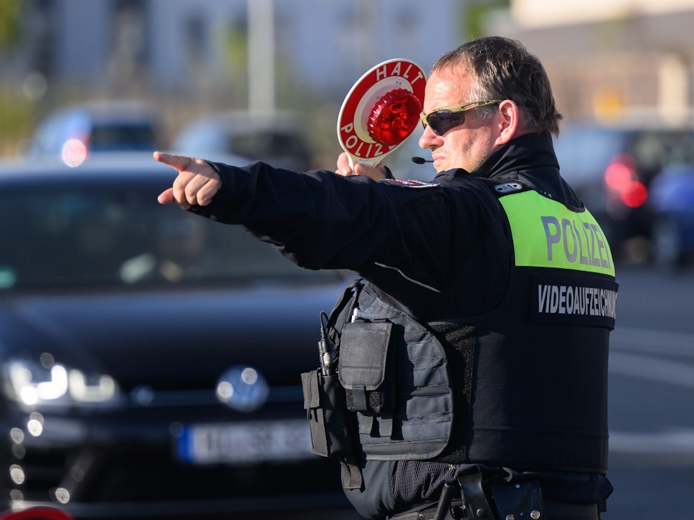 Ein Polizist der Polizei Hildesheim winkt Autofahrer zu einer Kontrolle raus.