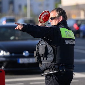 Ein Polizist der Polizei Hildesheim winkt Autofahrer zu einer Kontrolle raus.