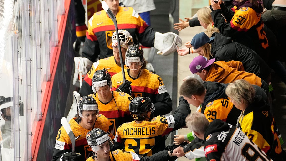 Die deutschen Eishockeyspieler jubeln mit den Fans nach ihrem Sieg.