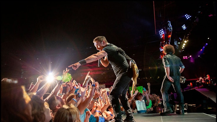 Bruce Springsteen interagiert mit den Zuschauerinnen und Zuschauern in der ersten Reihe.