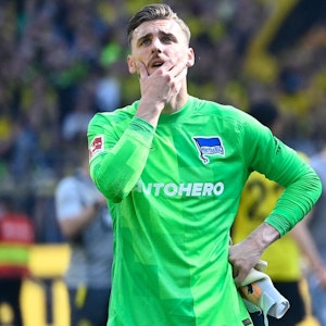 Marcel Lotka steht nach der Niederlage von Hertha BSC bei Borussia Dortmund enttäuscht vor der Berliner Fankurve