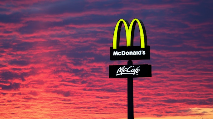 Der Abendhimmel leuchtet rötlich am 30. November 2020 hinter einem McDonalds-Logo.