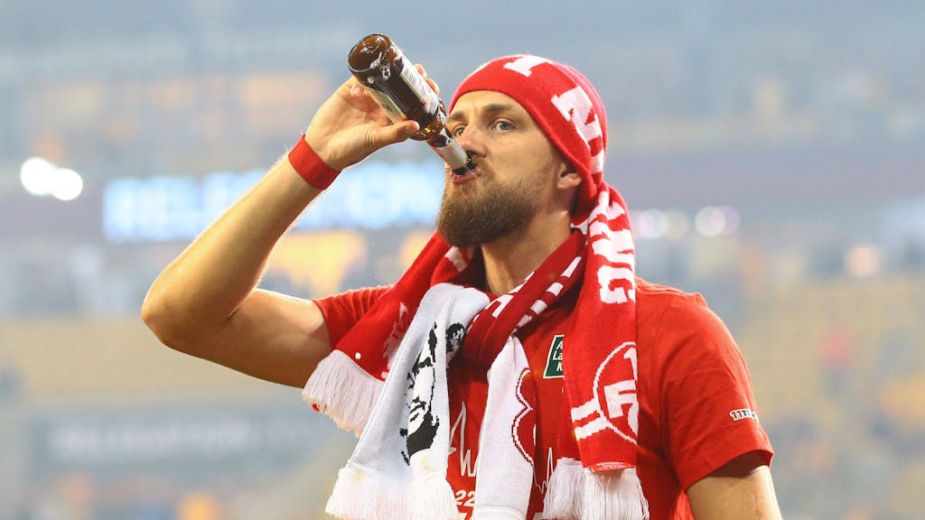 Mit Fan-Schals und einem kühlen Bier in der Hand feiert Mike Wunderlich den Zweitliga-Aufstieg des 1. FC Kaiserslautern.