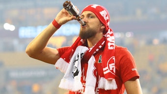 Mit Fan-Schals und einem kühlen Bier in der Hand feiert Mike Wunderlich den Zweitliga-Aufstieg des 1. FC Kaiserslautern.