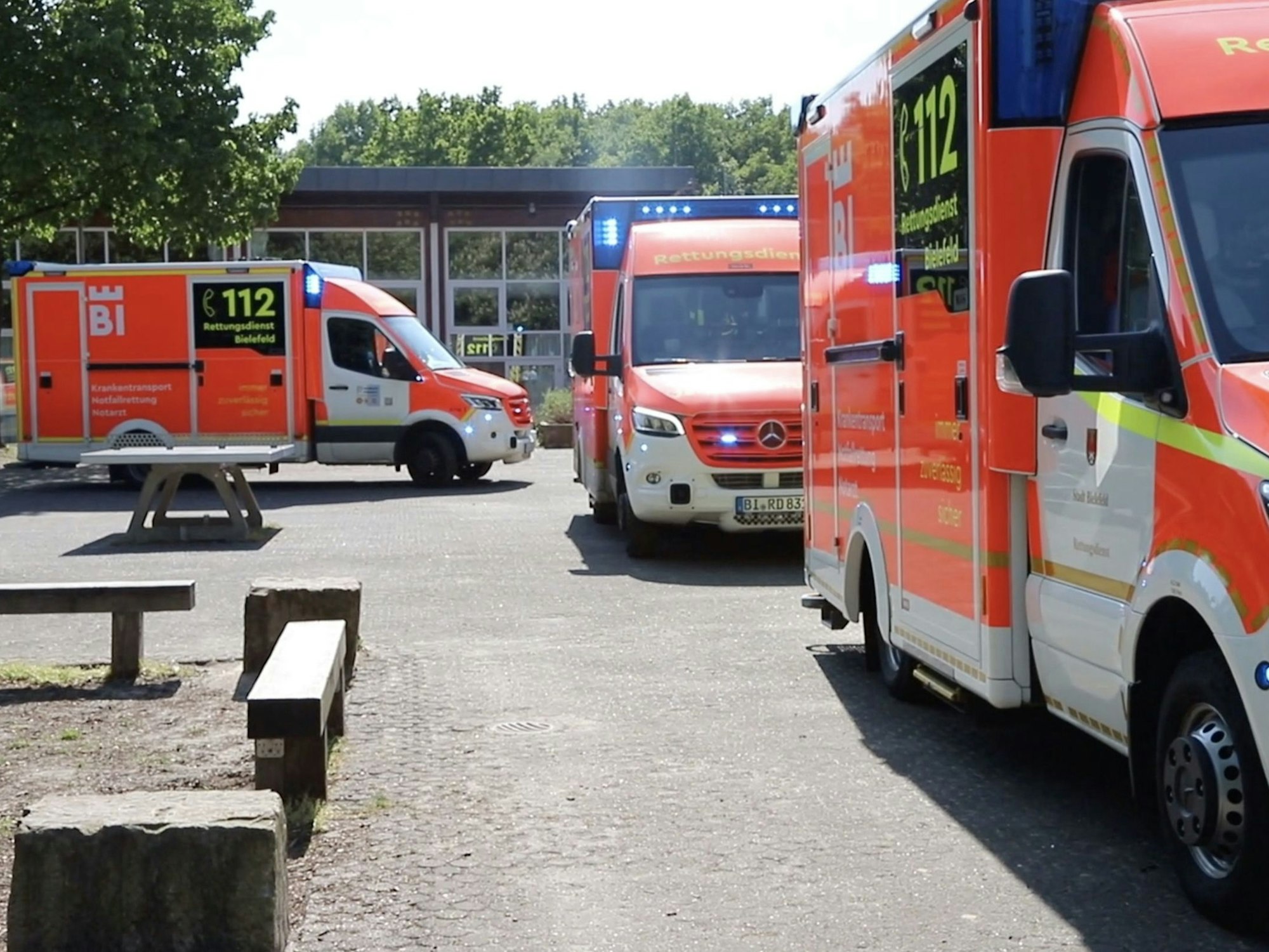 Einsatzfahrzeuge vom Rettungsdienst Bielefeld stehen vor der Schule.