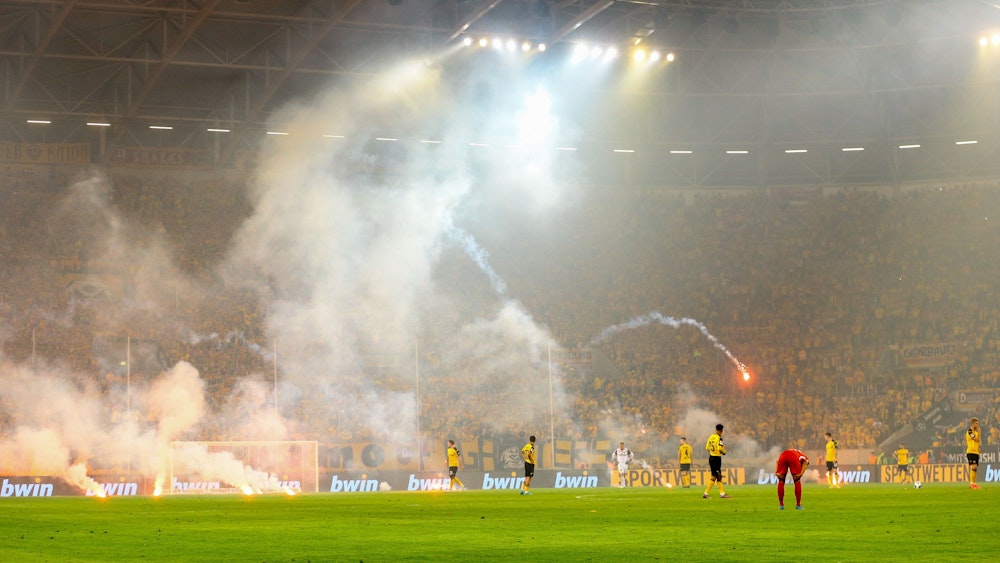 Dresden Fans werfen Pyrotechnik auf das Spielfeld.