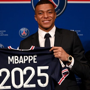 Kylian Mbappé hält bei der Verkündung seiner Vertragsverlängerung bis 2025 bei Paris Saint-Germain ein Trikot mit seinem Namen und der Zahl 2025 hoch