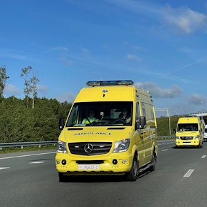 Mehrere Krankenwagen sind auf einer Autobahn unterwegs.