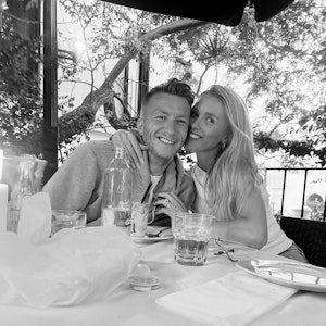 Marco Reus und seine Frau Scarlett sitzen an einem Tisch.