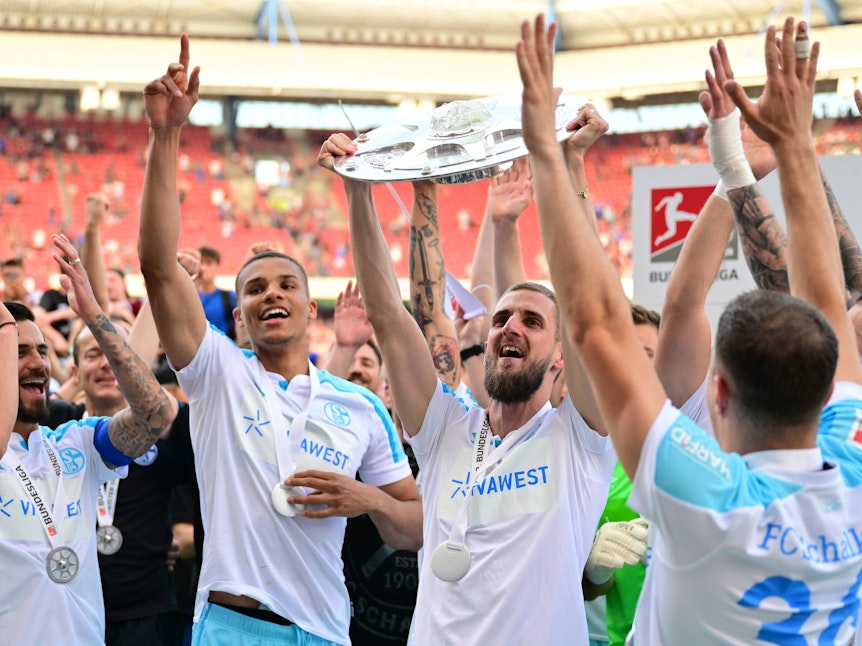 Dominick Drexler stemmt die Meisterschale der Zweiten Bundesliga in die Höhe und jubelt mit seinen Kollegen von Schalke 04.