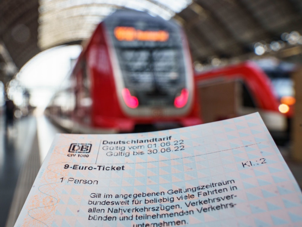 9-Euro-Ticket, das für ein Symbolbild vor einen Zug gehalten wird.