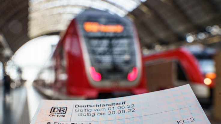 9-Euro-Ticket, das für ein Symbolbild vor einen Zug gehalten wird.
