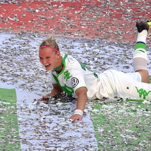 Alexandra Popp vom VfL Wolfsburg feiert im Konfetti liegend den Pokalsieg.