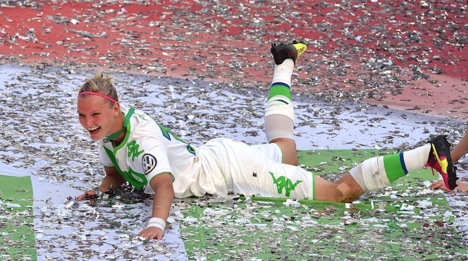 Alexandra Popp vom VfL Wolfsburg feiert im Konfetti liegend den Pokalsieg.