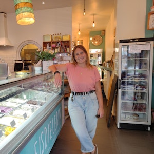 Ladeninhaberin Michaela Staffel lehnt sich lächelnd an die Eistheke der "Eisdielerin".