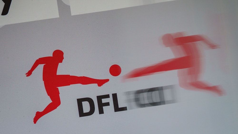 Das Logo der Deutschen Fußball Liga (DFL) spiegelt sich vor Beginn einer Pressekonferenz in einer transparenten Trennscheibe auf dem Podium.