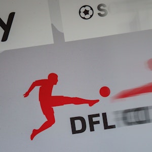 Das Logo der Deutschen Fußball Liga (DFL) spiegelt sich vor Beginn einer Pressekonferenz in einer transparenten Trennscheibe auf dem Podium.