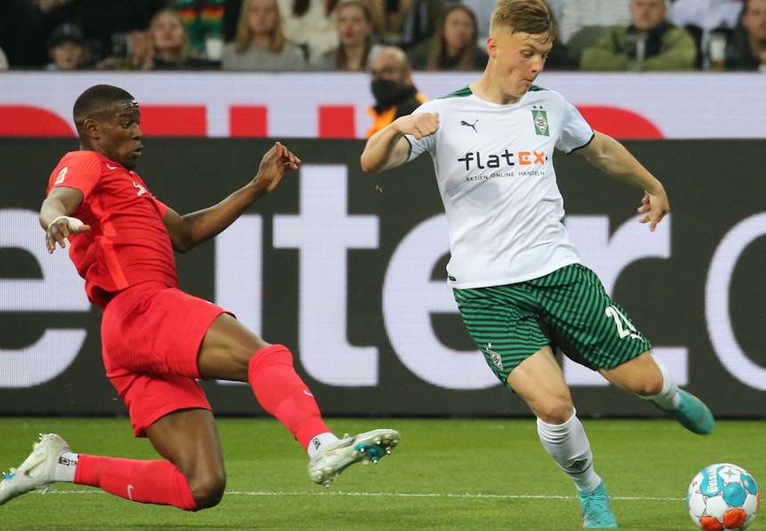 Luca Netz gewinnt den Ball gegen Nordi Mukiele. Aufgenommen während der Bundesliga-Partie zwischen Borussia Mönchengladbach und RB Leipzig am 02. Mai 2022.