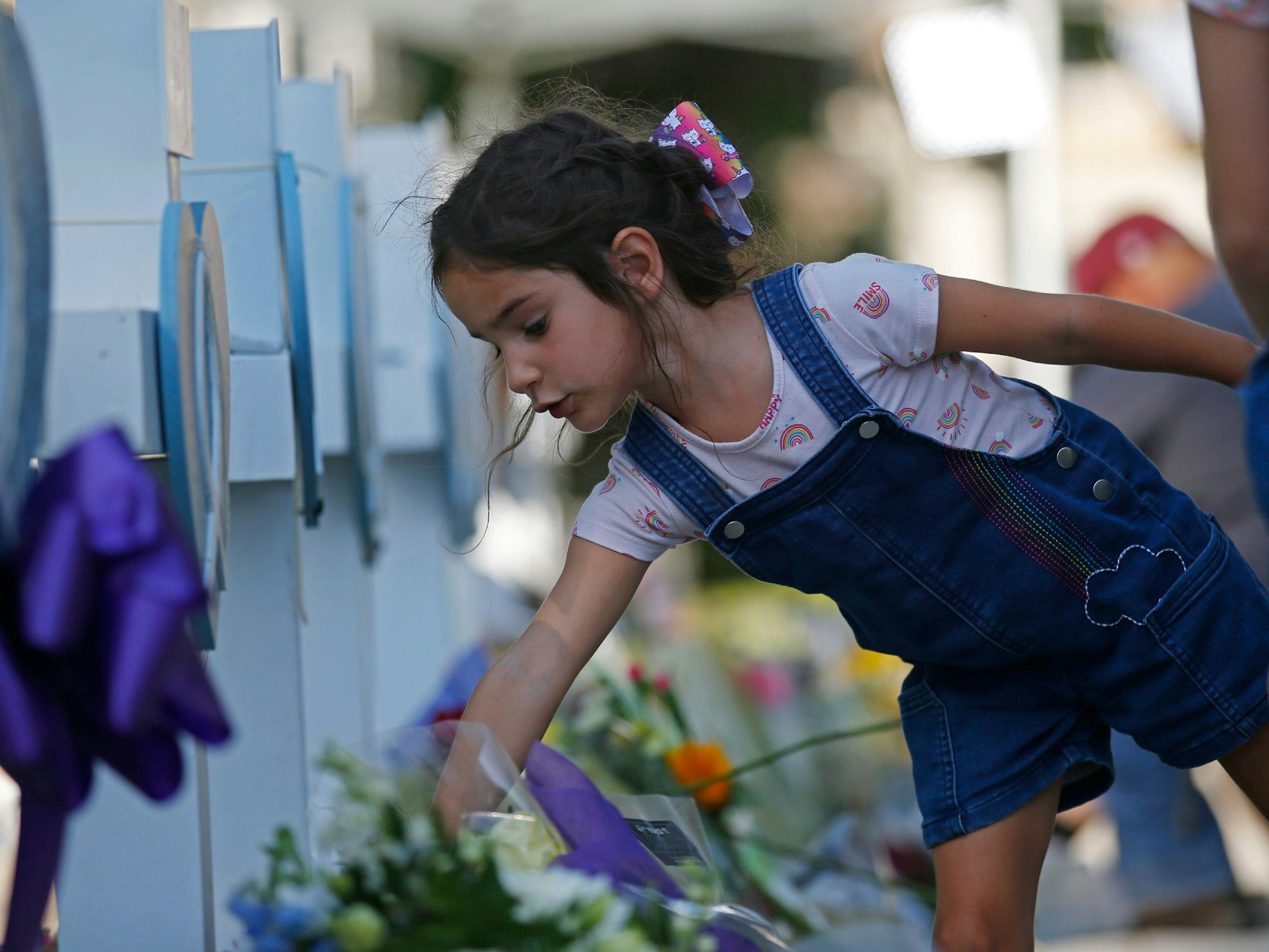 Ein unbekanntes Mädchen legt Blumen an einer Grundschule in Uvalde (Texas) nieder. Ein 18-Jähriger hatte die Schule am Dienstag, 24. Mai 2022, gestürmt und 21 Menschen getötet.
