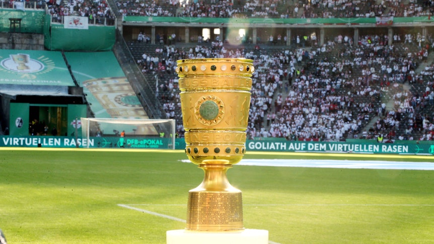 Der DFB-Pokal im Berliner Olympiastadion. Auf diesem Foto ist die Trophäe am 21. Mai 2022 zu sehen. Der Pokal leuchtet in der Abendsonne.