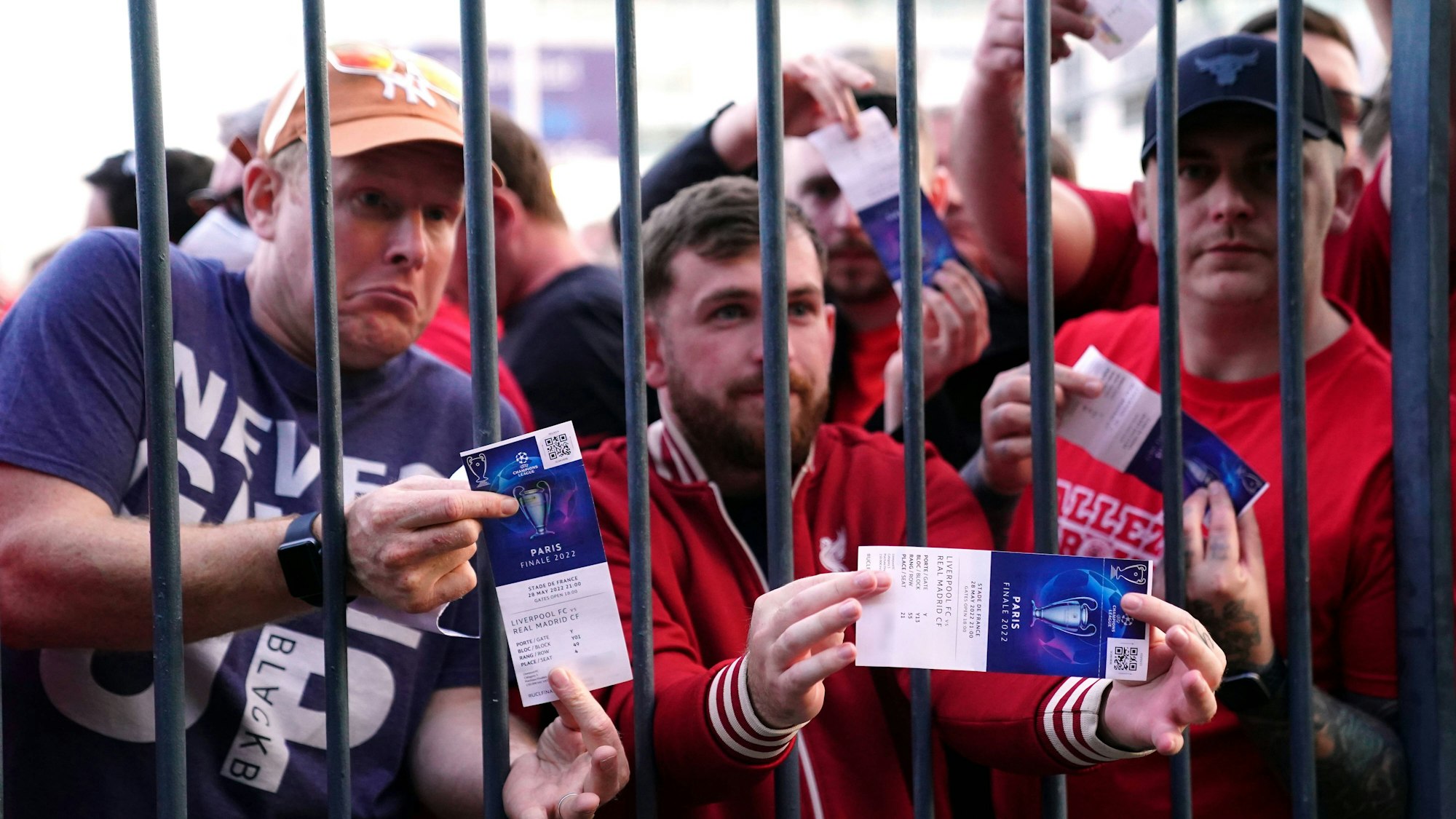 Fans des FC Liverpool stehen mit gültigen Tickets vor den verschlossenen Toren des Stade de France.