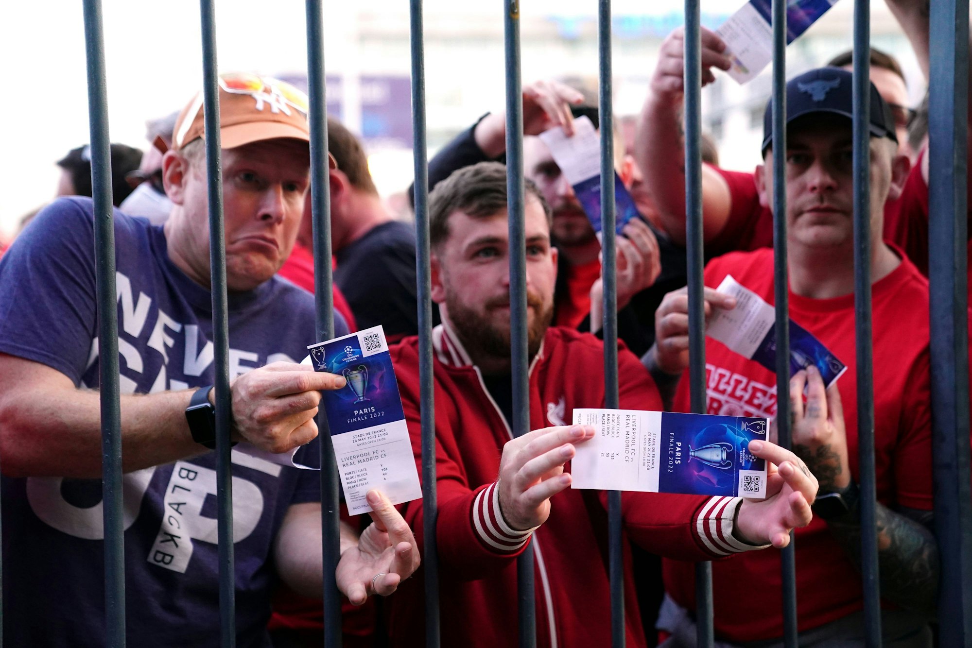 Fans des FC Liverpool stehen mit gültigen Tickets vor den verschlossenen Toren des Stade de France.