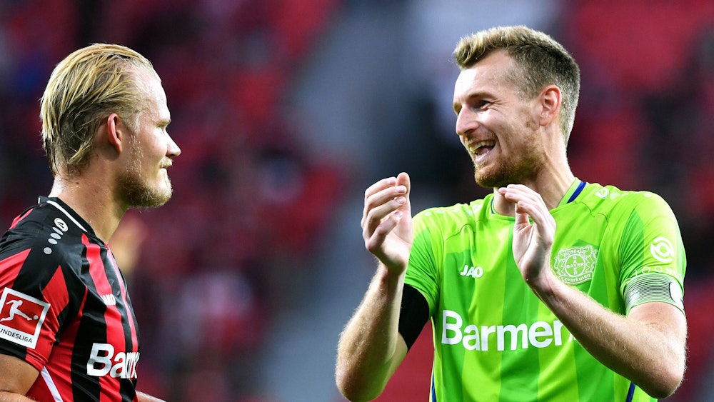 Joel Pohjanpalo und Lukas Hradecky lachen sich während des Bundesliga-Spiels gegen Borussia Mönchengladbach an