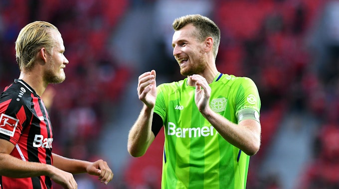 Joel Pohjanpalo und Lukas Hradecky lachen sich während des Bundesliga-Spiels gegen Borussia Mönchengladbach an