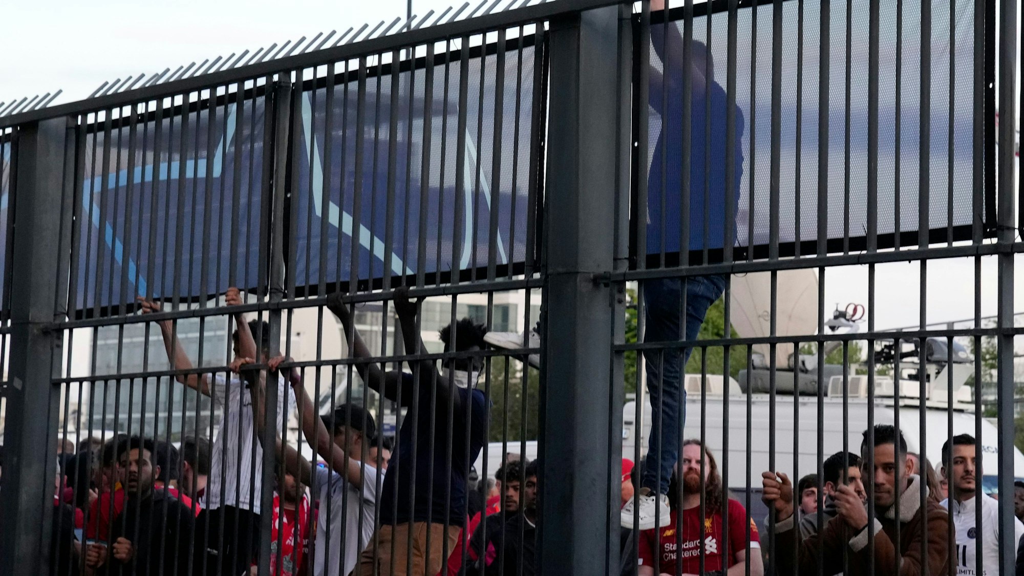 Vereinzelt versuchen Menschen, über die Stadion-Zäune beim Finale der Champions League zu klettern.