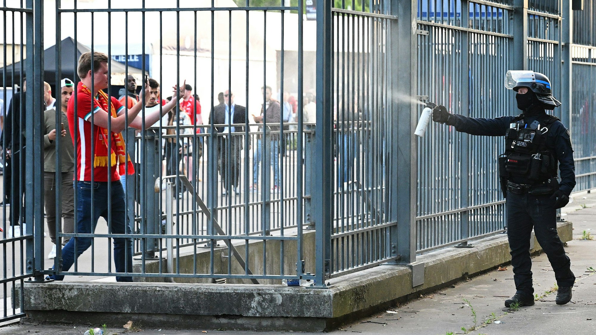 Wahllos setzt ein Polizist Tränengas gegen einen wartenden Fan ein.