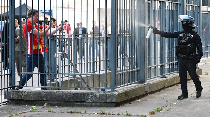Szenen rund um das Stadion: Ein Polizist sprüht Tränengas.