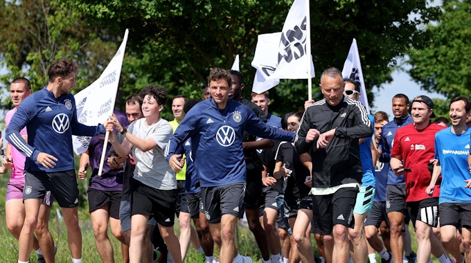 Die Nationalspieler laufen mit Adidas-Mitarbeitenden im DFB-Camp.