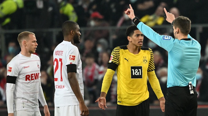 Jude Bellinham beschwert sich im Spiel von Borussia Dortmund beim 1. FC Köln beim Schiedsrichter Daniel Siebert.