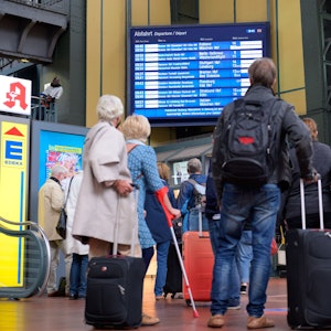 Zahlreiche Reisende vor einer Anzeigetafel mit An- und Abfahrtszeiten der Züge am Hamburger Hauptbahnhof.