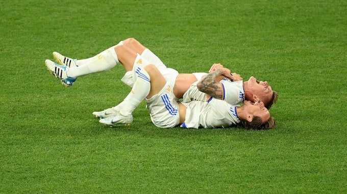 Toni Kroos und Luka Modrić von Real Madrid feiern am Boden liegend gemeinsam den Champions-League-Triumph.