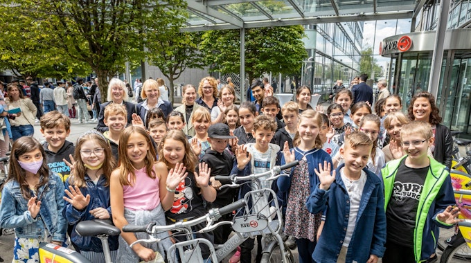Die Schülerinnen und Schüler der KGS Horststraße, die den Wettbewerb um die Gestaltung der Fahrräder gewonnen haben. Hintere Reihe links Schirmfrau Elfi Scho-Antwerpes und KVB-Chefin Stefanie Haaks (2. v. l.).