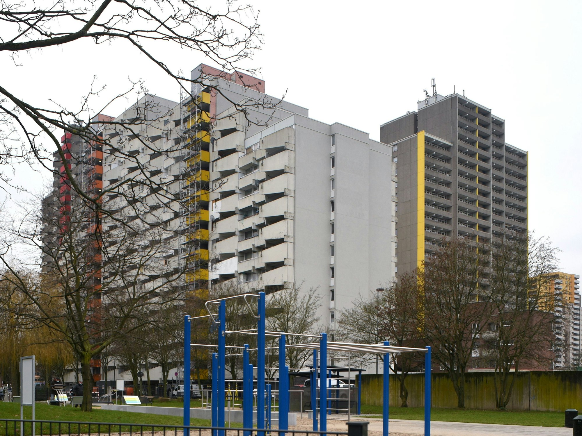 Hohe Wohnbauten in Köln-Chorweiler hinter einem Spielplatz.