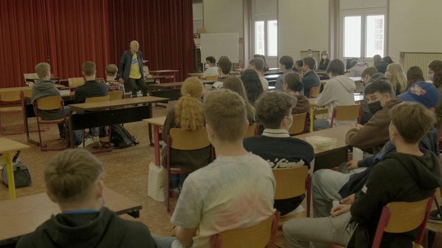 Günter Wallraff (hinten) im Gespräch mit Schülerinnen und Schülern am Gymnasium Nonnenwerth.