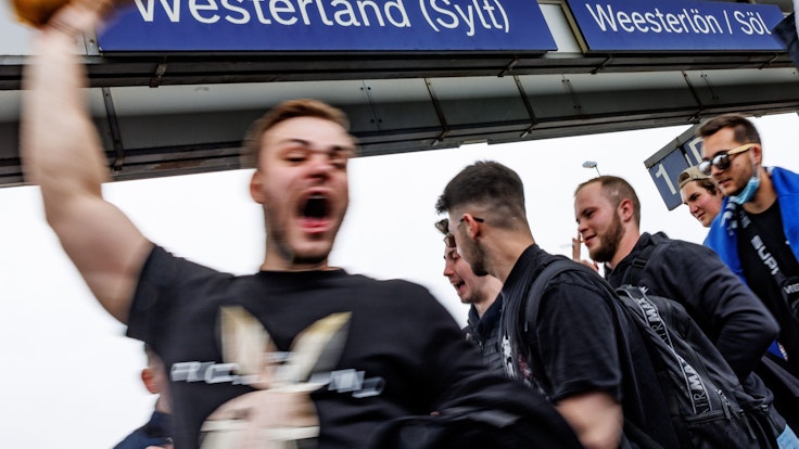Eine Touristengruppe feiert auf dem Bahnhof von Westerland auf Sylt am Samstag (4. Juni) die Ankunft.