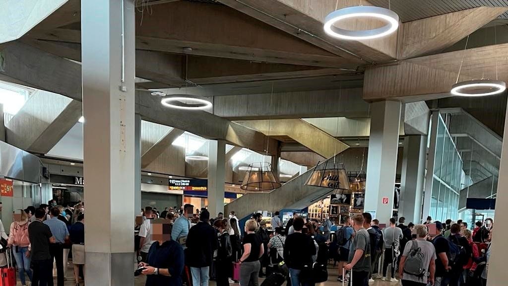 Reisende stehen am Flughafen Köln/Bonn vor der Sicherheitskontrolle Schlange.