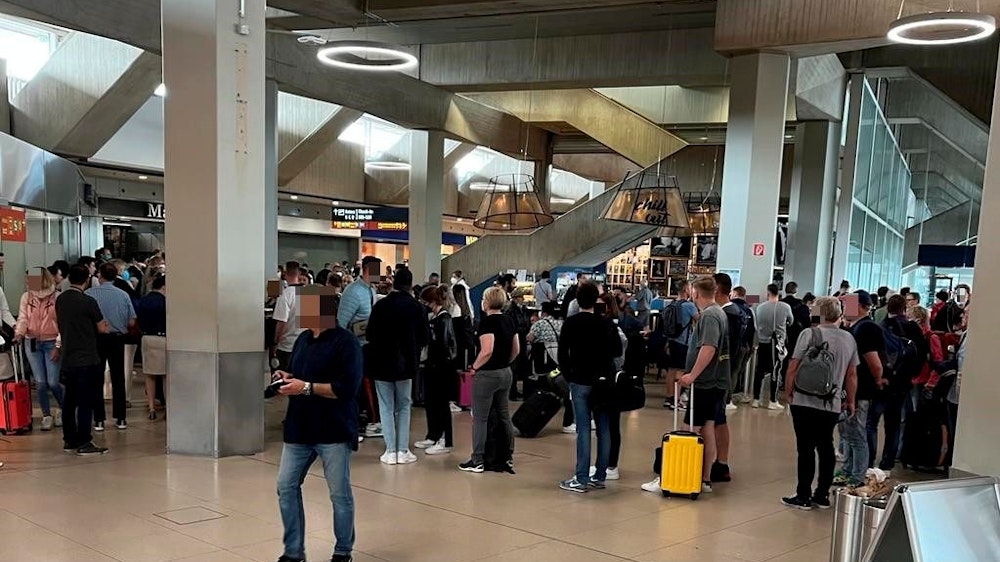 Reisende stehen am Flughafen Köln/Bonn vor der Sicherheitskontrolle Schlange.