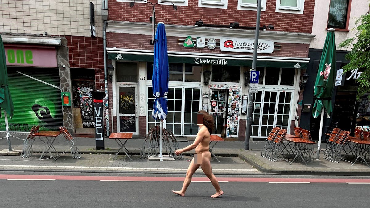 Mann geht nackt über die Venloer Straße in Köln.
