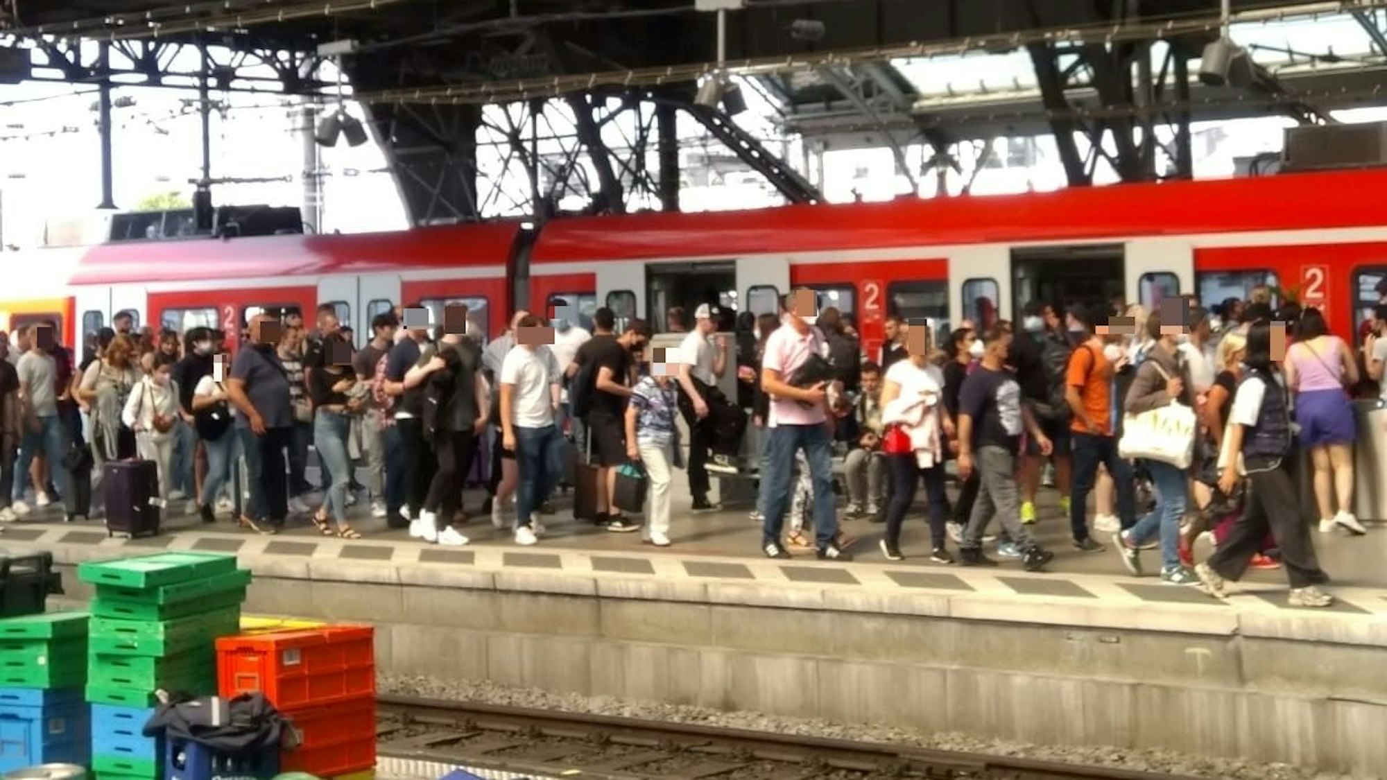 Zahlreiche Menschen auf einem vollen Bahnsteig in Köln.