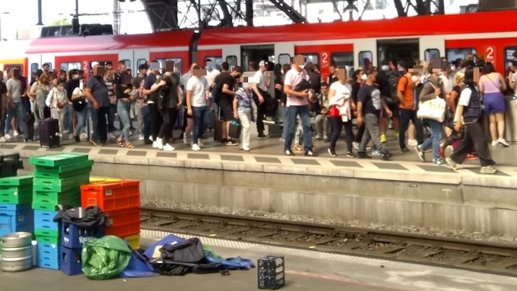 Zahlreiche Menschen auf einem vollen Bahnsteig in Köln.