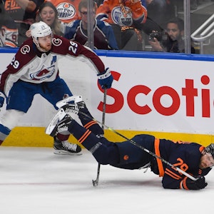 Nathan MacKinnon foult Oilers-Superstar Leon Draisaitl, der sinnbildlich auf die Nase fällt.