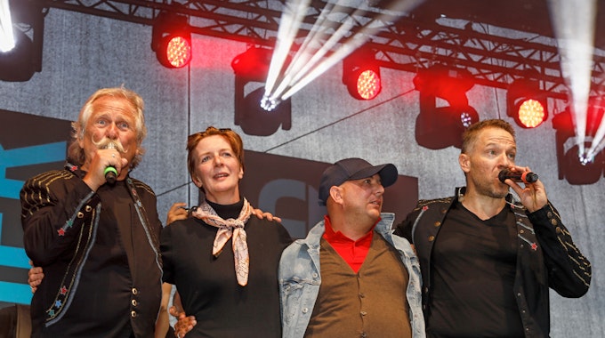 Henning Krautmacher und Patrick Lück von den Höhnern stehen mit Anke und Michael aus Duisburg auf der Bühne.