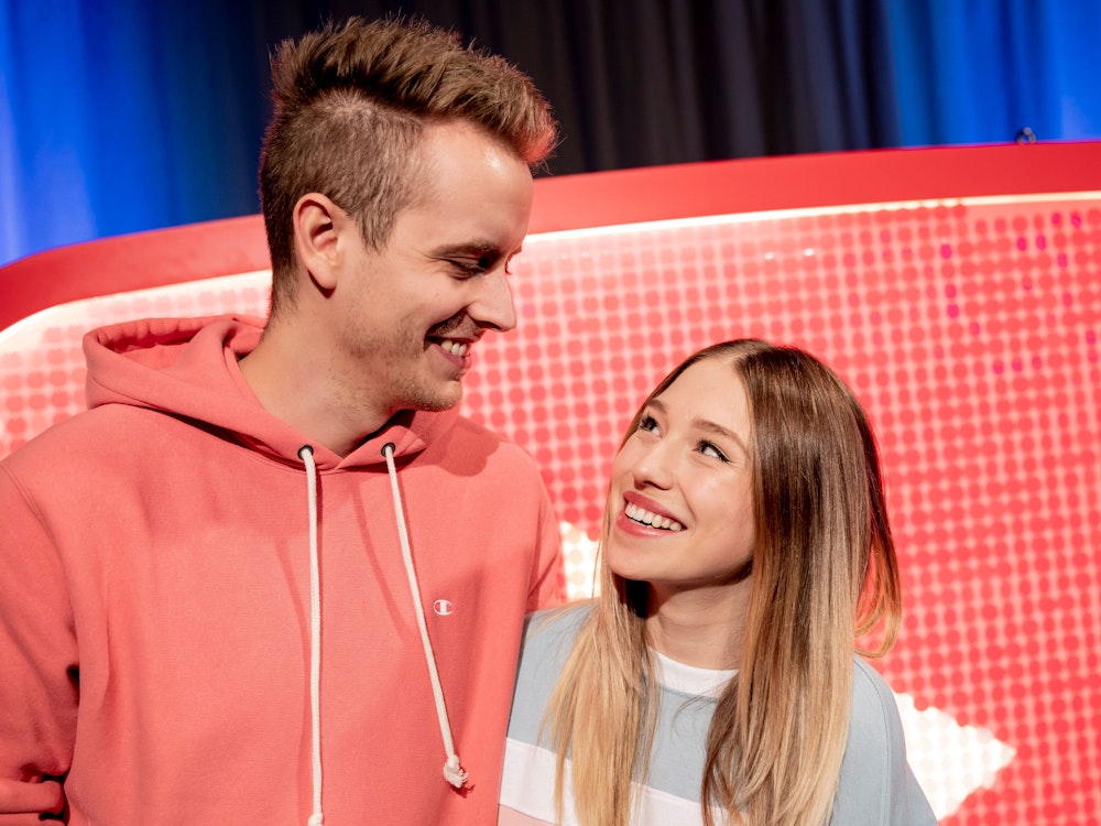 Das YouTuber-Paar Julian Claßen und Bianca Claßen schauen sich beim YouTube-Jahresrückblick 2018 im YouTube Space Berlin vor einem YouTube-Logo an.